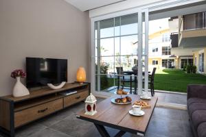 a living room with a television and a table at Lara Beach Homes in Lara