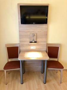 a table with two chairs and a tv on a wall at Salzburgrooms in Salzburg