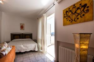 ein Schlafzimmer mit einem Bett und einem großen Fenster in der Unterkunft Appartamento Arzachena Costa Smeralda in Arzachena