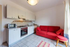 ein Wohnzimmer mit einer roten Couch in der Küche in der Unterkunft Appartamento Arzachena Costa Smeralda in Arzachena