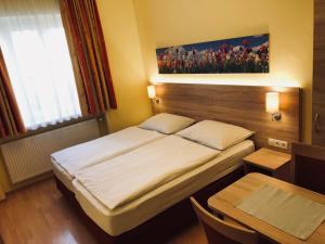 a small bedroom with a bed and a table at Salzburgrooms in Salzburg