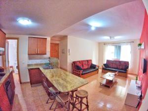 a kitchen and living room with a table and chairs at Piso 8 Personas Wifi 500Mb in Telde