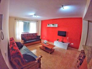 een woonkamer met een rode muur bij Piso 8 Personas Wifi 500Mb in Telde