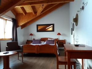 Schlafzimmer mit einem Bett, einem Schreibtisch und einem Tisch in der Unterkunft Hôtel de Fully in Fully
