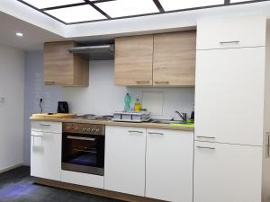 a kitchen with white cabinets and a stove at Monteurzimmer Obersulm in Obersulm