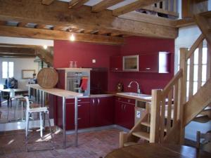 a kitchen with red walls and a kitchen with a sink at La Palestriere in Cuy-Saint-Fiacre