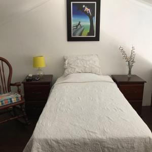 Un dormitorio con una cama blanca con una foto en la pared en Residencial Ruddy XXVII, en Santiago de los Caballeros