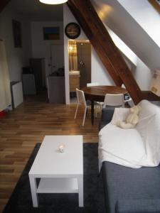 ein Wohnzimmer mit einer Couch mit einem Teddybär drauf in der Unterkunft Appartement et gîte Chez l'Habitant in Guebwiller