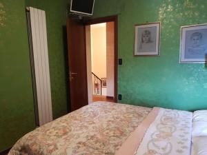 a bedroom with a bed and a green wall at Le Dimore di Angelo in SantʼEufemia a Maiella