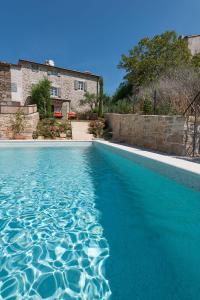 a swimming pool with blue water in front of a house at Casa Meloni in Motovun