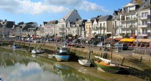 um grupo de barcos ancorados num rio com edifícios em Chez Annick em Guérande