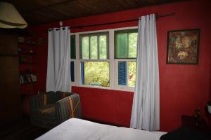 1 dormitorio con pared roja y ventana en Punta Ballena- Rancho Civil- Casa de Campo, Piscina y Playa, en Punta del Este 29 fotos más