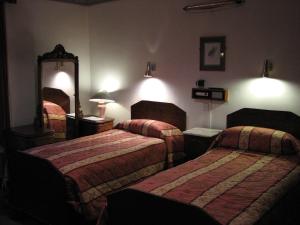 Giường trong phòng chung tại Lancaster Hotel