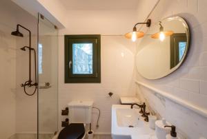 a bathroom with a sink and a mirror and a toilet at North Point Houses in Fiskardho