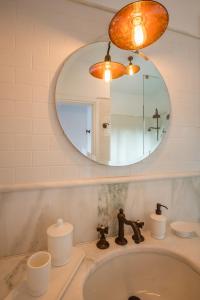 een badkamer met een wastafel en een spiegel bij North Point Houses in Fiskardho