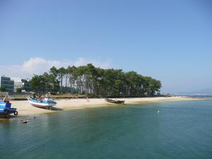 una playa con dos barcos en el agua en Apartamento de Mar y Playa en Illa de Arousa, en A Illa de Arousa