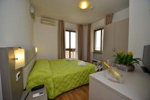 una camera con un letto verde di Hotel Bella Peschiera a Peschiera del Garda