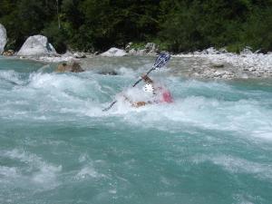 a person in a raft in a river with a paddle at Apartment Makuc in Bovec +15 photos