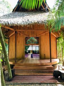 a bamboo building with a thatched roof and a hallway at Casa Amazonas in Puerto Maldonado