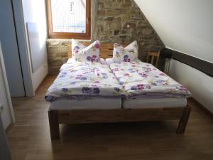 a bed with four pillows on top of it at Ferienwohnungen Haus Hinneres in Schalkenmehren