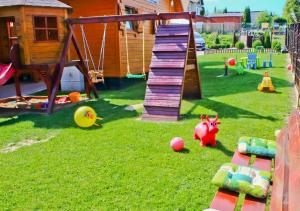 a backyard with a playground with a slide and toys at Kakadu domki letniskowe Niechorze in Niechorze