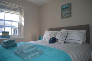 una camera da letto con un letto con asciugamani blu di Appledore Factory ad Appledore