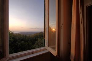 an open window with a view of the sunset at Villa Eugenia in Livorno