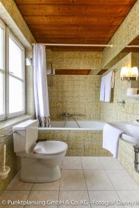 ein Badezimmer mit einem WC, einer Badewanne und einem Waschbecken in der Unterkunft Schmied von Kochel in Kochel