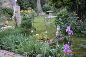 - un jardin fleuri avec une table et des chaises dans l'établissement Mas Alpilles Soleil, à Saint-Rémy-de-Provence