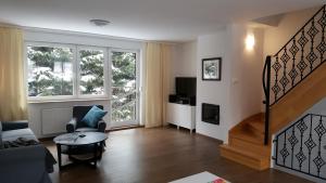 a living room with a couch and a table and a staircase at Apartament rodzinny z ogrodem - Bliżej Zdroju in Polanica-Zdrój