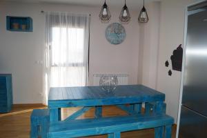 a blue wooden table in a room with a window at Apartamento Turístico “El Yugo” in Arguedas