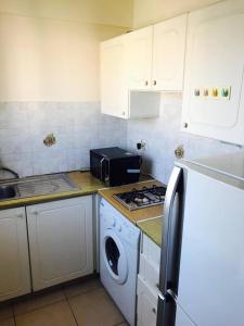 cocina con fogones, fregadero y lavadora en Seaside Apartments, en Pafos