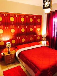 a bedroom with a red bed with a red headboard at Seaside Apartments in Paphos City