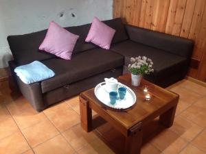 Sofá negro con almohadas rosas y mesa de centro en Finca El Cantero, en Garachico