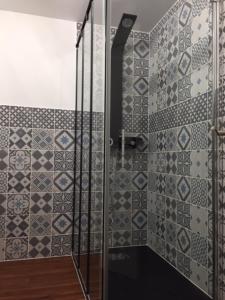 een douche met een glazen deur in de badkamer bij Le Nessmann in Sarlat-la-Canéda