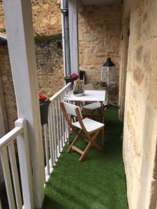 eine Veranda mit einem Tisch und Stühlen auf dem Balkon in der Unterkunft Le Nessmann in Sarlat-la-Canéda