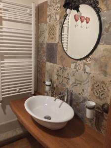ein Bad mit einem Waschbecken und einem Spiegel in der Unterkunft appartamento pescocostanzo in Pescocostanzo