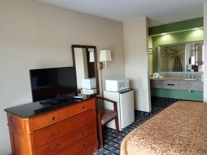 a hotel room with a dresser with a television on it at Americas Best Value Inn - Augusta / South in Augusta