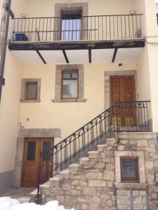 ein altes Haus mit Treppe und Balkon in der Unterkunft appartamento pescocostanzo in Pescocostanzo