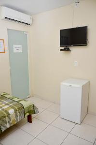 a room with a flat screen tv on the wall at Caminho da Costa Verde in Itaguaí