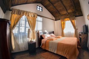 una camera da letto con un letto e una grande finestra di Hosteria San Jose de Sigchos a Sigchos