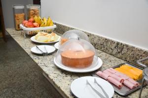 a counter top with plates and bowls of food on it at Caminho da Costa Verde in Itaguaí