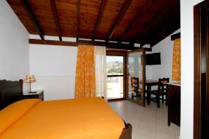a bedroom with a bed and a kitchen with a table at Afrodite Hotel Apartments in Myrina