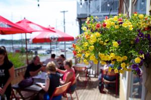 a group of people sitting at a restaurant with flowers at Salt Shaker Deli & Inn in Lunenburg