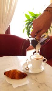 a person pouring coffee into a cup on a table at Affittacamere Parella in Turin