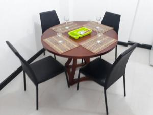 a wooden table with four chairs and a table with wine glasses at Playa Los Cocos in Santa Marta