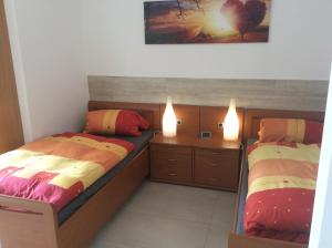 two beds in a bedroom with two lights on at ZUM LÖWE in Waltershausen