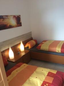 two beds in a room with two lamps on them at ZUM LÖWE in Waltershausen
