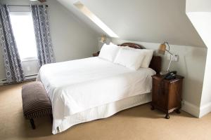 a bedroom with a large white bed and a window at Salt Shaker Deli & Inn in Lunenburg
