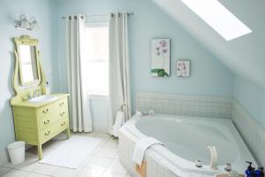 a bathroom with a large tub and a sink at Salt Shaker Deli & Inn in Lunenburg